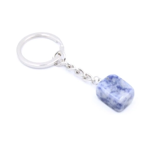 Macro shot of polished blue natural crystal stone keychain with silver metal ring