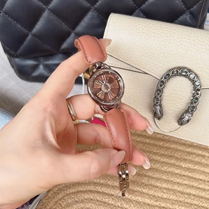 Close-up of rose gold watch with gear-shaped dial and pink leather band on a luxury background