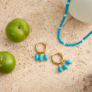 Detail of 18k gold stainless steel hoop earrings with three dangling turquoise beads