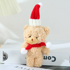Close-up of plush bear doll with Christmas hat and scarf showing soft fleece texture