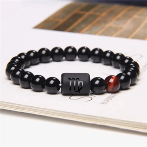 Detail of Virgo constellation bracelet with black beads and a tiger eye stone bead
