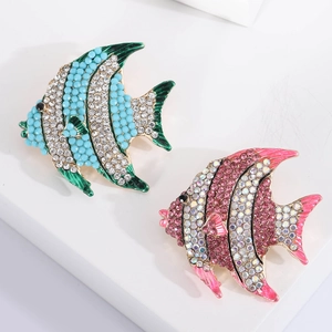 Elegant crystal-encrusted fish brooches set in blue and pink tones on a white base