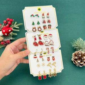 Festive Christmas earring set with Santa, elk, and snowman studs on a green display card