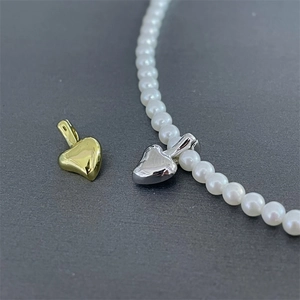 Detail view of S925 sterling silver heart locket pendants with white pearl necklace