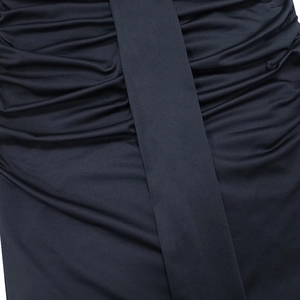 Détail de la robe noire élégante montrant le design froncé et la bande de tissu