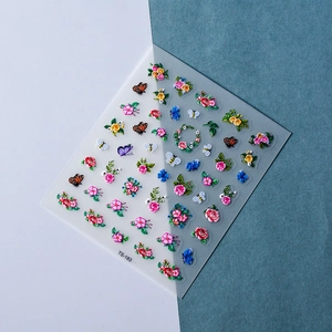 Macro detail of 5D embossed nail stickers featuring floral, butterfly and bee patterns