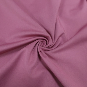 Macro di tessuto tessile rosa-viola che mostra la trama morbida e il drappeggio pieghettato