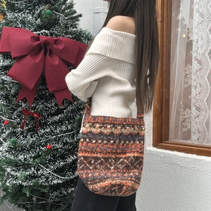Detail of knit shoulder bag with retro jacquard pattern in warm festive setting