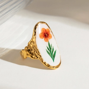 Macro detail of vintage gold floral ring with hammered texture and oval flower motif