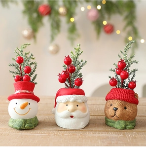 Detail of Christmas resin figurines featuring Santa Claus, Snowman and Bear with holly