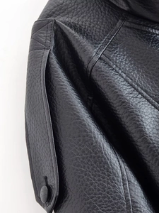 Gros plan sur la veste en cuir PU noir montrant le grain de cuir et les surpiqûres