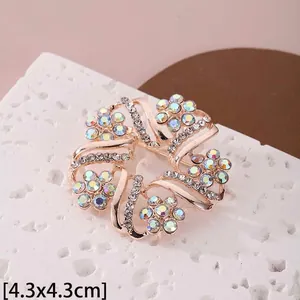Détail macro d'une broche fleur or rose de 4,3 cm avec strass irisés scintillants