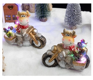 Close-up of resin Christmas cows on motorcycles with LED lights and winter decor