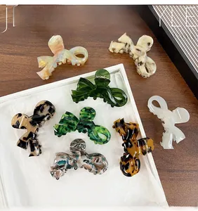 Detailed collection of acetate bow hair claws in various marble patterns and tortoiseshell