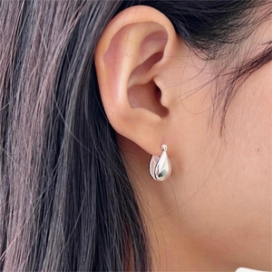 Close-up of polished 925 sterling silver waterdrop earrings on model's ear