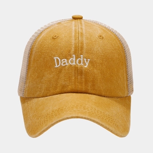 Detail der Daddy-Stickerei auf einer atmungsaktiven senfgelben Trucker-Kappe mit Mesh-Rücken