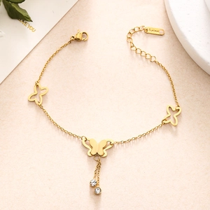 Detail shot of golden stainless steel butterfly charms and sparkling zircon droplets