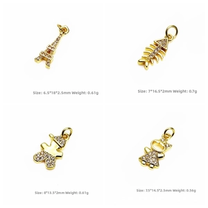 Detail of gold pendants with zircons featuring Eiffel Tower, boy and girl motifs