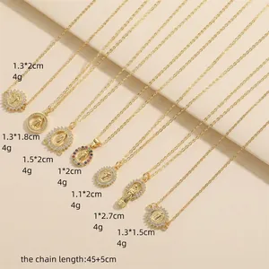 Gold religious necklace set with Virgin Mary and cross charms on white texture background