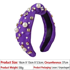 Detail of purple knotted headband with white pearls and gold claw-set crystals on fabric