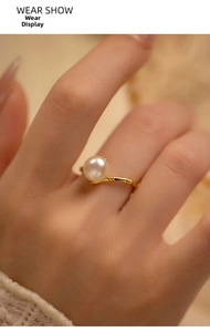Macro shot of a gold-plated bamboo joint pearl ring on finger with elegant luster