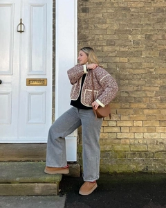 Close-up of a floral quilted jacket styled with a brown saddle bag and platform boots