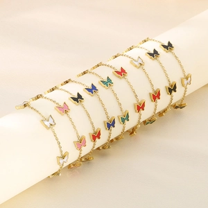 Detail of butterfly pendants on gold bracelets in various colors like white and blue