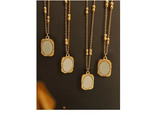 Detail of rose embossed pendant necklace with 18K gold plated hammered texture finish