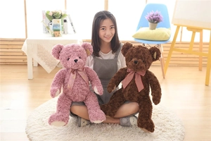 Detail of soft curly plush teddy bears in pink and brown with cute ribbon bow ties