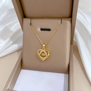 Luxurious gold heart pendant necklace with dancing zircon stones in a jewelry box