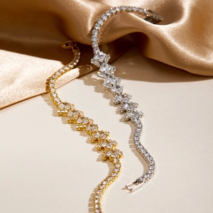 Detail of luxury gold and silver tennis bracelets with cluster cubic zirconia stones