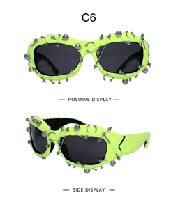 Detail of neon yellow punk sunglasses with silver metal studs and spikes on black lenses