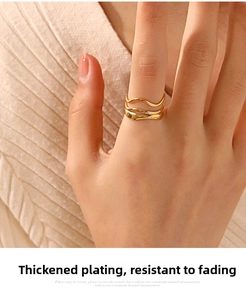 Detail of 18K gold plated triple-layer wave ring worn on finger with soft knit background