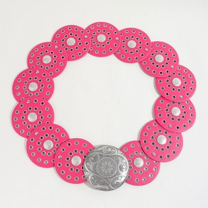 Close-up of pink leather disc belt with silver studs and a vintage floral buckle