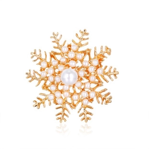 Close-up of gold snowflake brooch with elegant pearl inlay on a white background