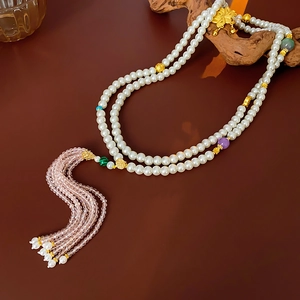 Detail of beaded floral necklace with long pink crystal tassels and gold accents