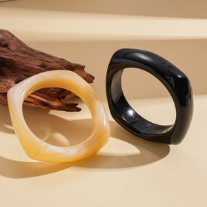Minimalist acrylic geometric square bangles in solid black and cream marble finishes