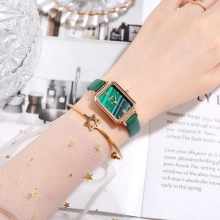 Detail of vintage square green dial watch with gold star bracelet on model wrist