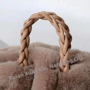 Detailed view of woven leather handle and fluffy faux rabbit fur on the tan handbag