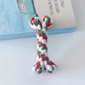 Macro shot of durable cotton rope bone toy in red, white and green for dog dental health