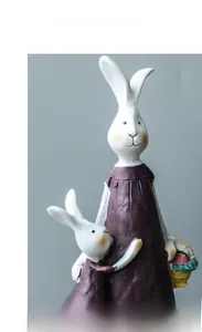 Detail of hand-painted resin mother and baby rabbit figurines with pastoral textures