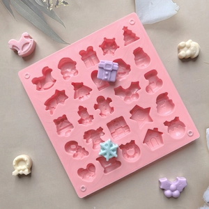 Close-up of pink silicone mold featuring 24 festive Christmas shapes for chocolate baking