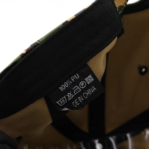 Detail shot of the interior washing label showing 100% PU material and camo baseball cap fabric