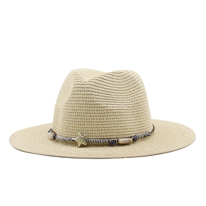 Detail of beige straw hat featuring striped band, wooden beads and gold star charm