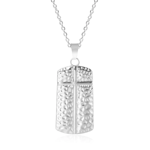 Detail of silver stainless steel rectangular pendant with cross and hammered texture