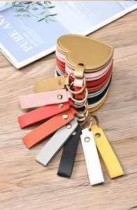 Close-up of heart-shaped leather keychain mirrors in various vibrant colors on a wooden table