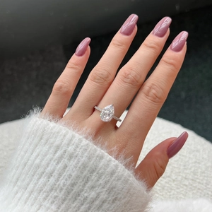 Macro shot of luxury S925 pear cut silver ring with pavé diamonds on a model's hand