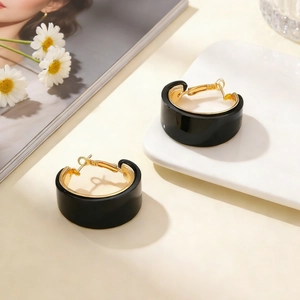 Elegant C-shaped leopard style earrings in black and gold high-polished metal finish