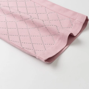 Détail du pantalon Y2K rose avec motifs en strass diamant sur tissu en denim doux