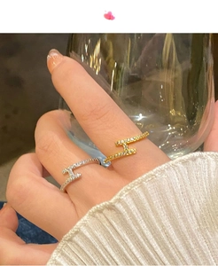 Détail des bagues H en or et argent avec micro-pavage en zircone sur la main du mannequin